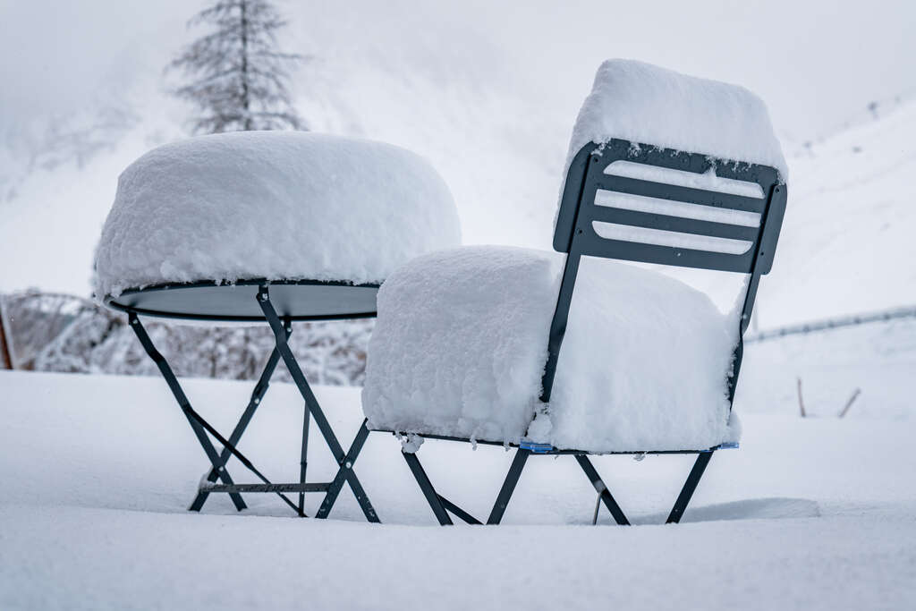 Table et chaise recouvertes de neige fraîche à Tignes