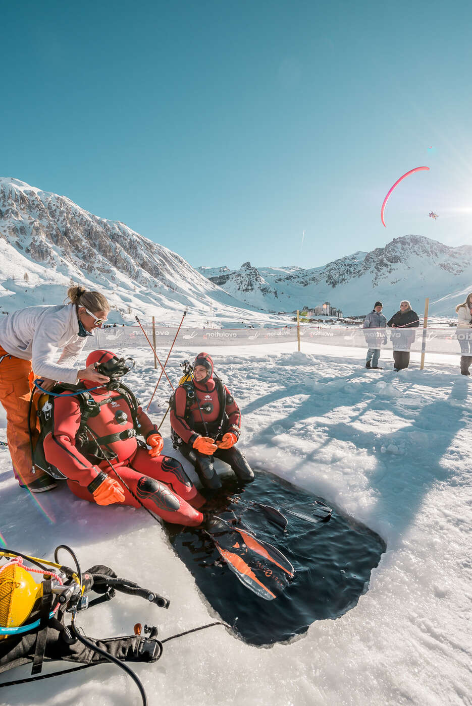 Divers beneath the frozen lake of Tignes